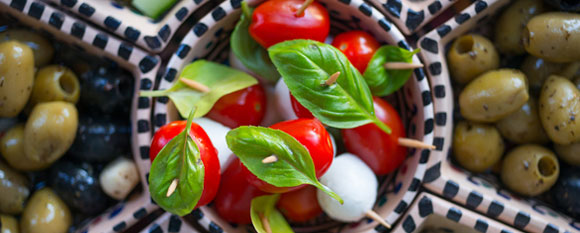 Porzellanplatte mit Oliven und Tomaten